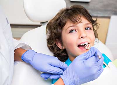 A boy display their perfect teeth, serviced by Glenn Smile Center's skilled pediatric dentist team.