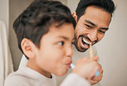 Father and Child flash bright smiles thanks to the expert pediatric dentistry care at Glenn Smile Center.